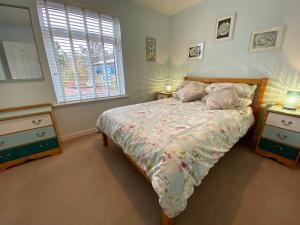a bedroom with a bed and two dressers and a window at Little Haven in Gairloch