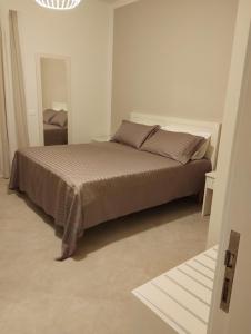 a bedroom with a bed in a white room at LA LAMPARA in Carrara