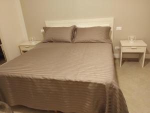 a bed in a bedroom with two end tables at LA LAMPARA in Carrara