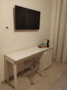a white desk with a television on a wall at LA LAMPARA in Carrara