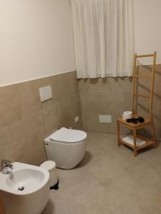 a bathroom with a white toilet and a sink at LA LAMPARA in Carrara +2 photos