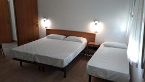 een slaapkamer met 2 bedden en 2 verlichting aan de muur bij Hotel Garden in Bellaria-Igea Marina