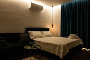 ティラナにあるTranquil Studio in Tiranaの小さなベッドルーム(ベッド1台、ソファ付)