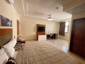 a bedroom with a large bed and a desk at Hotel Casa Libertad in Santo Domingo