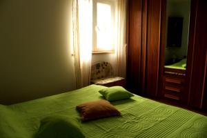 sypialnia z zielonym łóżkiem i oknem w obiekcie Apartment Vita w Korčuli