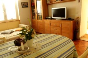 salon ze stołem, telewizorem i łóżkiem w obiekcie Apartment Vita w Korčuli