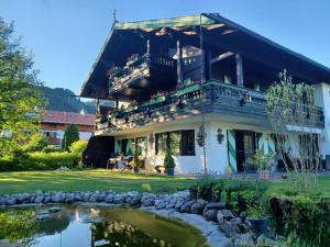 a house with a pond in front of it at Chalet Dr. Datz in Reit im Winkl