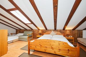 a bedroom with a wooden bed and a couch at Chalet Dr. Datz in Reit im Winkl
