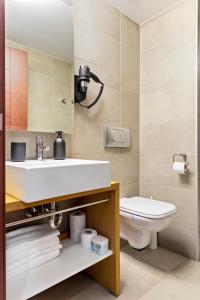 een badkamer met een wastafel en een toilet bij The Central Deluxe in Boekarest