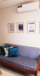un sofá azul en una habitación con fotos en la pared en Riveri Salinas V53, en Salinas
