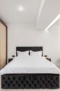 a bedroom with a large bed with a black headboard at The Central Deluxe in Bucharest