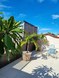 un patio con mesa, sillas y palmeras en Pousada Coqueiral en Aracruz