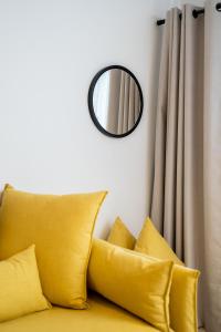 um espelho numa parede acima de um sofá com almofadas em Aretousa InCreteble Cretan Residences Collection em Sitia