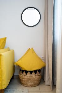 un oreiller jaune dans un panier à côté d'un mur dans l'établissement Aretousa InCreteble Cretan Residences Collection, à Siteía