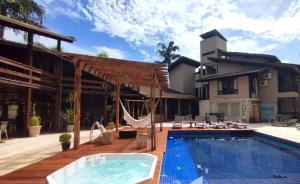 ein Pool mit Hängematte und ein Haus in der Unterkunft WINNER BEACH HOTEL in Juréia
