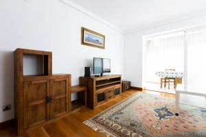a living room with a tv and a entertainment center at Zurubi-gain. Basquenjoy in Hondarribia
