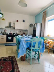 comedor con mesa azul y sillas en casa Rituzza, en San Leone
