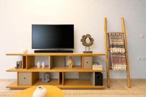 a television on a wooden shelf in a room at Aretousa InCreteble Cretan Residences Collection in Sitia