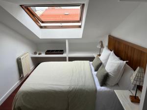 una camera con un grande letto e un lucernario di apartamento centro a Ferrol