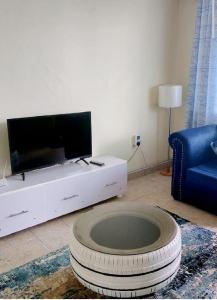 a living room with a tv and a large tire at Rubi Apartment in Naivasha