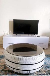 a living room with a tv on top of a large tire at Rubi Apartment in Naivasha