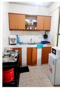 cocina con armarios marrones y nevera blanca en Rubi Apartment, en Naivasha
