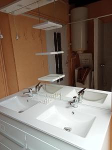 Panjas的住宿－Maison de campagne Les Chênes.，一间带两个盥洗盆和大镜子的浴室