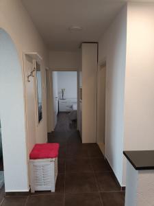 - un couloir avec un pouf rouge dans la chambre dans l'établissement Apartman A&D, à Ljubuški