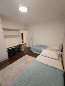 Apartman A&D في ليوبوشكي: غرفة نوم بسريرين ومكتب فيها