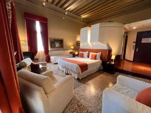a large hotel room with two beds and chairs at Ruzzini Palace Hotel in Venice