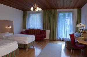 a hotel room with two beds and a couch at Gasthof Pichler in Bruck an der Mur