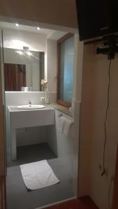 bagno con lavandino bianco e specchio di Gasthof Pichler a Bruck an der Mur