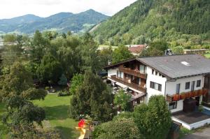 ein Haus auf einem Feld mit Bergen im Hintergrund in der Unterkunft Gasthof Pichler in Bruck an der Mur