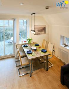 y sala de estar con mesa de comedor y sillas. en Bootshaus in den Duenen - 5 - "Ferienwohnung Strandgut" en Wangerooge