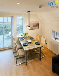 a dining table and chairs in a living room at Bootshaus in den Duenen - 5 - "Ferienwohnung Strandgut" in Wangerooge