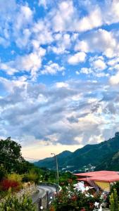 eine gewundene Straße mit blauem Himmel und Wolken in der Unterkunft Agriturismo da Regina in Tramonti