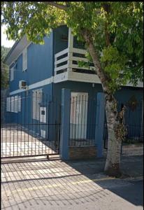 un edificio azul con un árbol delante de él en LOFT DONA MARIA, en Bento Gonçalves