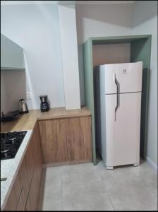 a kitchen with a white refrigerator and a stove at LOFT DONA MARIA in Bento Gonçalves