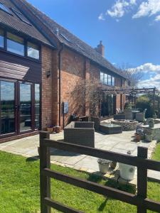 a brick house with a wooden fence in front of it at The Barn in Bishops Tachbrook