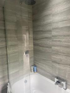 a bathroom with a tub and a glass shower at The Barn in Bishops Tachbrook
