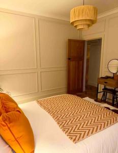 Dormitorio con cama con almohada naranja en Cottage in Pembroke, Close to beaches, en Pembrokeshire