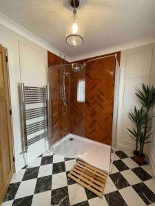 a bathroom with a tub and a checkered floor at Cottage in Pembroke, Close to beaches in Pembrokeshire