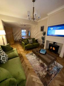 a living room with a green couch and a flat screen tv at Cottage in Pembroke, Close to beaches in Pembrokeshire
