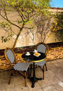 - une table et deux chaises avec un bol de nourriture dans l'établissement Hotel Le Cardinal Rueil Centre, à Rueil-Malmaison