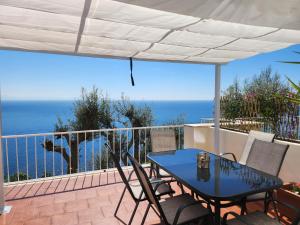 a table and chairs on a balcony with the ocean at Margiolà Amalfi in Amalfi