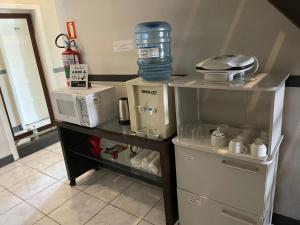 uma cozinha com um balcão com um micro-ondas e comodidades para preparar café em Hospedar Flats & Residence em Santa Cruz do Sul