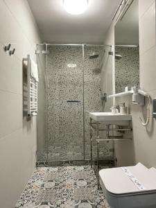 a bathroom with a shower and a toilet and a sink at Marina Śniardwy Resort in Nowe Guty