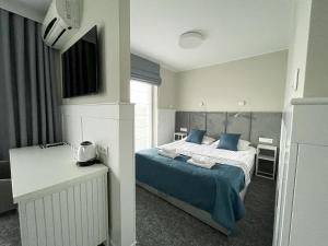 a bedroom with a bed with blue pillows at Marina Śniardwy Resort in Nowe Guty