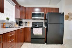 a kitchen with a black refrigerator and a microwave at Havana Ooh La La - Little Havana Calle 8 by Pattio in Miami