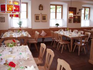 a dining room with tables and chairs and windows at Gasthof zur Post Oberwirt in Chieming